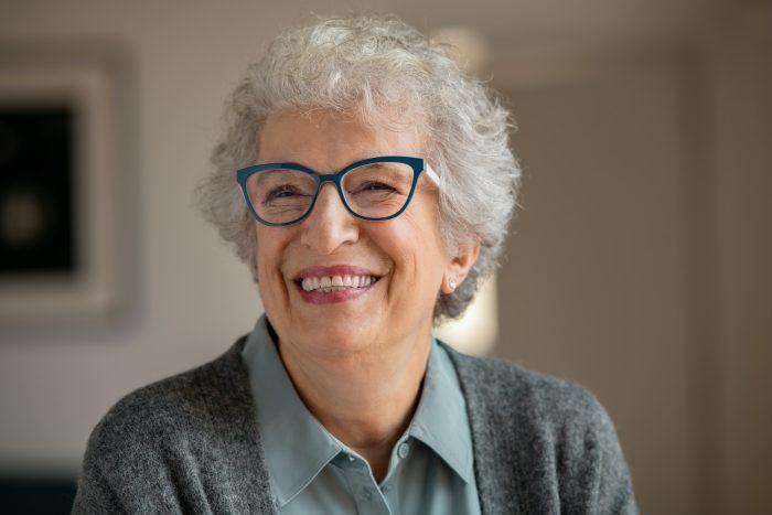 Happy senior woman with spectacles laughing at home